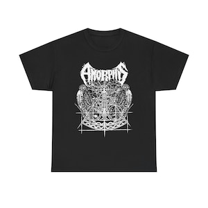 May include: A black short-sleeve t-shirt featuring a white graphic print on the chest. The design displays the word AMORPHIS in a stylized font above a detailed illustration of a geometric axe symbol flanked by two birds with intricate textures.