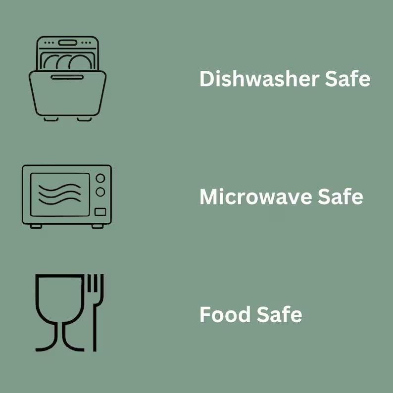 May include: A sage green graphic featuring three black line icons and white text. The top icon shows a dishwasher with the text Dishwasher Safe. The middle icon shows a microwave with the text Microwave Safe. The bottom icon shows a glass and fork with the text Food Safe.