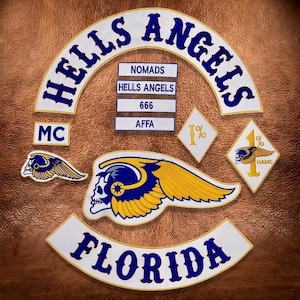 May include: A collection of embroidered patches featuring the text HELLS ANGELS in a large white arc with blue lettering, a FLORIDA bottom rocker, and smaller rectangular patches reading NOMADS, HELLS ANGELS, 666, and AFFA. Includes skull and wing emblems.
