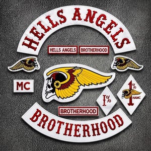 Puede incluir: Una colección de parches bordados con el texto HELLS ANGELS y BROTHERHOOD en rojo sobre fondo blanco. Incluye un emblema grande de calavera alada, dos parches más pequeños de calavera alada, dos parches en forma de diamante 1% y texto MC.