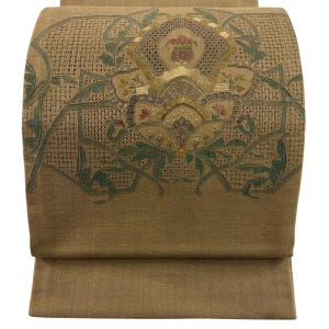 Könnte beinhalten: Ein beigefarbenes Textil mit gewebter Struktur und einem komplexen gestickten Blumenmotiv in Grün-, Gold- und gedeckten Rottönen. Das Design umfasst geometrische Linien und ein zentrales stilisiertes Blumenmuster auf der Stoffoberfläche.