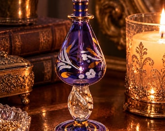 Frasco de perfume de vidrio egipcio soplado a mano de color púrpura con detalles florales dorados y aplicador de vidrio.