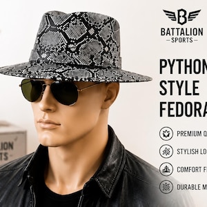 Puede incluir: Un sombrero fedora con un patrón de piel de pitón en blanco y negro, usado por un maniquí con gafas de sol de aviador oscuras. El texto BATTALION SPORTS PYTHON STYLE FEDORA es visible, junto con iconos de PREMIUM QUALITY, STYLISH LOOK, COMFORT FIT y DURABLE MATERIAL.