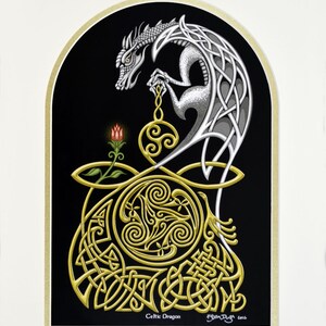 May include: A silver Celtic dragon with intricate knotwork design is depicted in a black and gold frame. The dragon is holding a golden orb with a Celtic knot design. The image is titled "Celtic Dragon" and signed by the artist.