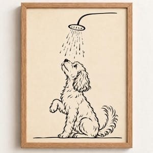 Op de afbeelding: Een ingelijste kunstdruk met een zwarte lijntekening van een krulharige hond die zit en omhoog kijkt naar een douchekop. De hond heeft één poot opgetild en er zijn waterdruppels afgebeeld die uit de douchekop op de hond vallen.
