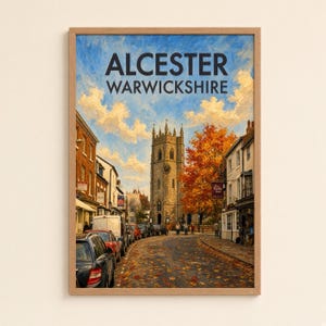 May include: A framed art print depicting a street scene in Alcester, Warwickshire. The image features a stone church tower, autumn trees with orange foliage, and a road covered in fallen leaves. The text ALCESTER WARWICKSHIRE is at the top.