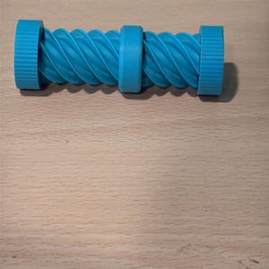 Può includere: Un oggetto cilindrico blu brillante con un anello centrale e due tappi alle estremità, collegati da una texture a coste a spirale. Il design è composto da due sezioni simmetriche con un motivo ritorto, creando un aspetto uniforme e geometrico.