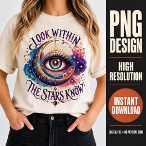 May include: A cream-colored t-shirt featuring a graphic print of a large, detailed human eye centered within a golden crescent moon. The design includes colorful cosmic clouds, stars, and the text "LOOK WITHIN" and "THE STARS KNOW" in dark blue.