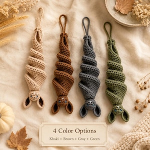 Puede incluir: Cuatro adornos de murciélago de ganchillo colgantes en color caqui, marrón, gris y verde. Cada murciélago tiene un cuerpo tejido en espiral, dos orejas puntiagudas y ojos pequeños. Un letrero indica: 4 Color Options, Khaki, Brown, Gray, Green.