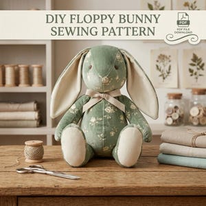 May include: A stuffed bunny toy made from sage green fabric with a white floral pattern, featuring long ears with cream-colored inner fabric, a cream ribbon bow at the neck, and dark brown embroidered eyes, presented as a DIY sewing pattern.