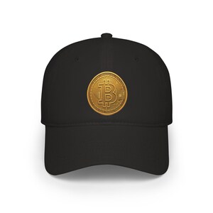 May include: A black baseball cap featuring a centered, circular gold-colored emblem. The emblem displays a prominent Bitcoin symbol in the middle, surrounded by the text "BITCOIN", "DECENTRALIZED", "PEER TO PEER", "DIGITAL GOLD", and "FINANCIAL FREEDOM".