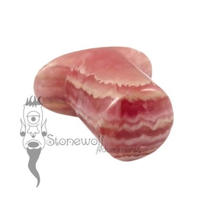 May include: Pink and white striped stone ear plug. The stone is a natural, organic shape with a smooth, polished finish.