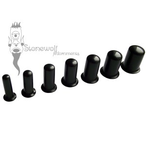 May include: A collection of seven black ear gauges, each with a cylindrical shape and a flared base. The gauges increase in size. The Stonewolf Adornments logo is in the top left corner.
