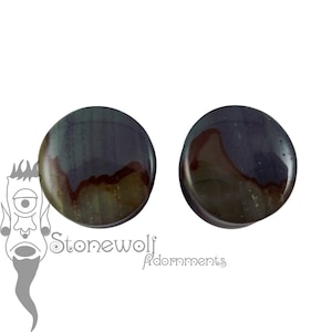 May include: Pair of round, dark green, brown, and black stone ear gauges. The gauges have a swirling pattern.