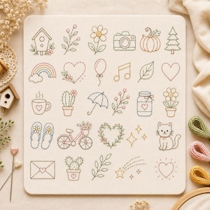 Può includere: Un campione di tessuto quadrato con una griglia di venticinque icone ricamate tra cui una casetta per uccelli, una fotocamera, una zucca, un arcobaleno, una nota musicale, un ombrello, un cactus in vaso, una bicicletta, un gatto e motivi floreali.