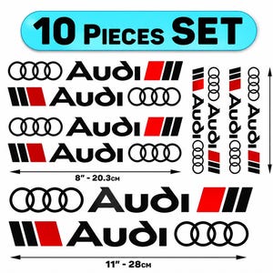 May include: A 10 pieces set of Audi vinyl decals featuring the brand logo in black with red and black rectangular accents. The sheet includes various orientations and sizes, with dimensions labelled as 20.3 cm by 13.5 cm and 28 cm.