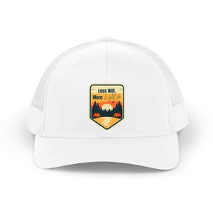 Peut inclure: Une casquette trucker blanche avec un écusson en forme de bouclier sur le devant. L'écusson présente un paysage de coucher de soleil avec des arbres, deux tentes orange et le texte Less Wifi. More Wyld Life en noir et orange sur fond clair.