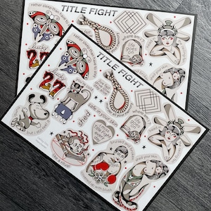 May include: A sticker sheet featuring various tattoo-style illustrations including a butterfly, a noose, a tombstone with a skull, a person with a ceiling fan head, a dog, a cat, a boxer, and text such as TITLE FIGHT, lucky 27, and other phrases.