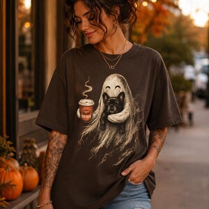 Könnte beinhalten: Ein anthrazitfarbenes Kurzarm-T-Shirt mit einer Grafik eines Geistes, der einen mit Boo-Brew beschrifteten Kaffeebecher hält, sowie einer schwarzen Französischen Bulldogge. Das T-Shirt hat einen Rundhalsausschnitt und eine lockere Passform.