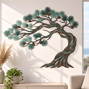 May include: A metal wall art sculpture depicting a windswept pine tree with a twisted trunk. The piece features a weathered copper and teal patina finish, with textured green needle clusters and small brown pinecones attached to the branches.