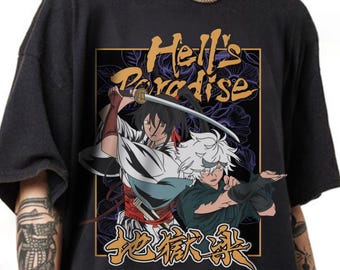 May include: A black t-shirt featuring a graphic print of two anime characters from Hell's Paradise. One character holds a katana, while the other is in a combat stance. The design includes the text Hell's Paradise and Japanese kanji characters.