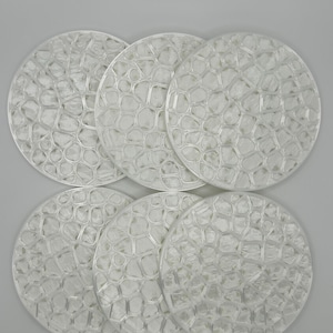 May include: A set of five circular white coasters, each featuring a raised, interconnected geometric lattice pattern that resembles a network of cells or a honeycomb structure, arranged in a two-row formation against a neutral background.