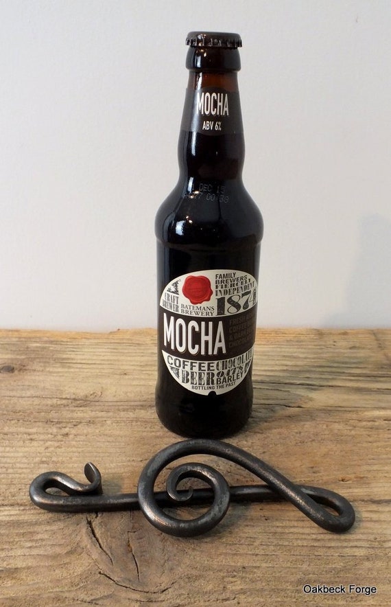A blacksmith actually hammered this treble clef bottle opener into existence — functional barware meets hand-forged musical art.
