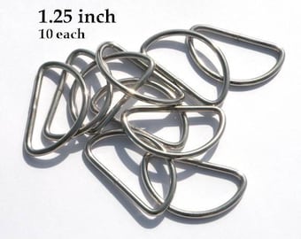 Puede incluir: Diez anillas en D plateadas de 1,25 pulgadas. Estas anillas se utilizan comúnmente para sujetar correas, asas u otros accesorios a bolsos, cinturones u otros artículos.