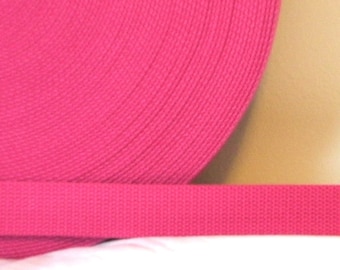 May include: A roll of bright pink webbing, a type of strong, woven fabric often used for straps, belts, and other applications.