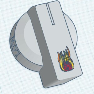 May include: A light grey circular control knob featuring a rectangular extension with a vertical groove. The word LOW is embossed on the side, and a small graphic of orange and red flames is printed on the top surface of the rectangular extension.