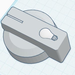May include: A light gray control knob featuring a rectangular handle attached to a circular base. The handle displays a small, white graphic of a light bulb and a thin, straight horizontal slot near the top edge, rendered in a 3D digital design style.