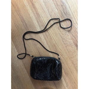 May include: A small black sequined evening bag with a black adjustable shoulder strap.