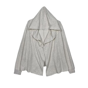 May include: A light gray heathered hooded cardigan with long sleeves and ribbed cuffs. The garment features an open front design with a draped, flowing silhouette and a pointed hood, crafted from a soft, lightweight knit fabric material.