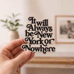 May include: An embroidered patch with a cream-colored background and black lettering that reads, It will Always be New York or Nowhere. The patch has a die-cut shape that follows the contours of the bold, stylized typography.