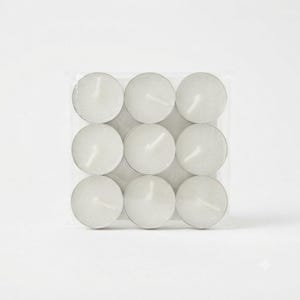 Puede incluir: Un paquete de plástico transparente de forma cuadrada que contiene nueve velas de té blancas dispuestas en una cuadrícula de tres por tres. Cada vela está alojada en una pequeña copa de metal redonda de color plateado con una mecha blanca centrada.