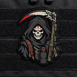 May include: A tactical morale patch featuring a grim reaper character wearing a dark hooded cloak, holding a large scythe with a red blade accent. The figure has a skull face with red eyes and is equipped with tactical gear in shades of gray and olive.