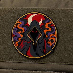 May include: A circular patch featuring a hooded figure in a dark cloak with glowing red eyes. The background displays swirling orange and purple smoke patterns and a cream-colored crescent moon, all enclosed within a thin yellow circular border.