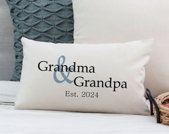 Puede incluir: Almohada blanca con el texto "Grandma & Grandpa Est. 2024" en letras negras y una ampersand azul.