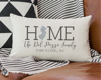 May include: A white throw pillow with the word "HOME" in black letters, a gray outline of the state of New Jersey, and the text "The Del Pozzo Family TOMS RIVER, NJ".