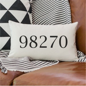 May include: White throw pillow with black text that reads "98270".