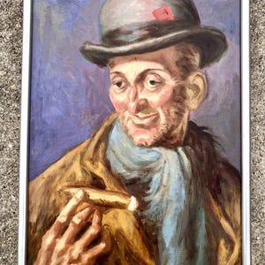 Op de afbeelding: Een ingelijst olieverfschilderij van een man met een grijze bolhoed met een rode speld. Hij houdt een sigaar in zijn rechterhand en draagt een blauwe sjaal om zijn nek. De achtergrond is in een paars-blauwe tint. Het schilderij is gesigneerd met "J. Breimer Wenen".