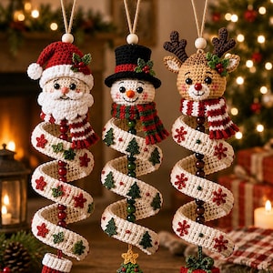 May include: Three hanging crochet ornaments featuring a Santa Claus, a snowman in a black top hat, and a reindeer. Each figure has a spiraling white body decorated with small green trees, red stars, and beads, ending in a stocking, tree, or gift.