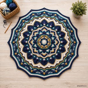 Op de afbeelding: Een ronde gehaakte mandaladeken met een complex geometrisch patroon in marineblauw, teal, crème en mosterdgeel. Het ontwerp bevat ingewikkelde bloemachtige motieven, gestructureerde steken en een geschulpte rand met puntige hoeken.