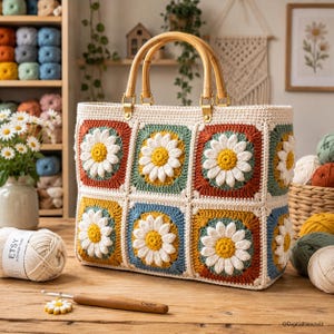 May include: A rectangular crochet tote bag featuring a pattern of daisy granny squares in shades of rust, sage green, mustard yellow, and blue, with white petals and yellow centers. The bag has two rounded bamboo handles and cream trim.