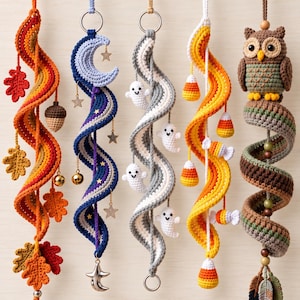 May include: Five hanging crochet spiral ornaments. The first features autumn leaves and an acorn. The second has a crescent moon and stars. The third displays small white ghosts. The fourth includes candy corn shapes. The fifth features a brown owl.