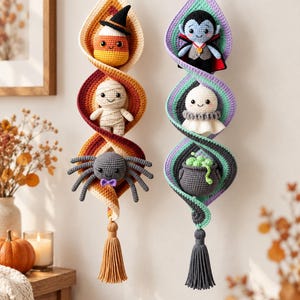 May include: Two vertical crochet wall hangings featuring spiral designs. The left hanging displays a candy corn, a mummy, and a spider in warm autumn tones. The right hanging features a vampire, a ghost, and a cauldron in cool purple and teal tones.