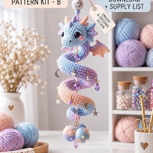 May include: A crochet dragon ornament featuring a pastel blue, purple, and peach gradient body with small wings, hanging from a cord with a constellation bead. It includes charms of stars, moons, and crystals, with text reading PREMIUM CROCHET PATTERN KIT - B, INSTANT DIGITAL DOWNLOAD + SUPPLY LIST, and UNIQUE & ORIGINAL DESIGN.
