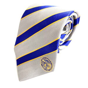 May include: A gray and white striped tie with a blue and yellow stripe pattern. The tie has a small gold and blue seal with the text "University of the Pacific 1851" on it.