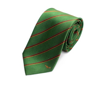 Könnte beinhalten: Grüne Krawatte mit roten und gelben Streifen. Die Krawatte ist aus glattem Stoff gefertigt und hat ein kleines gesticktes Design in der Nähe der Spitze. Die Krawatte ist aufgerollt und zeigt das Muster und die Textur.