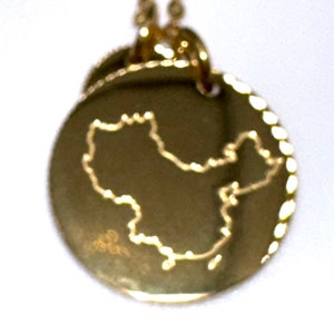 May include: Gold necklace with a round pendant featuring an outline of the shape of China.